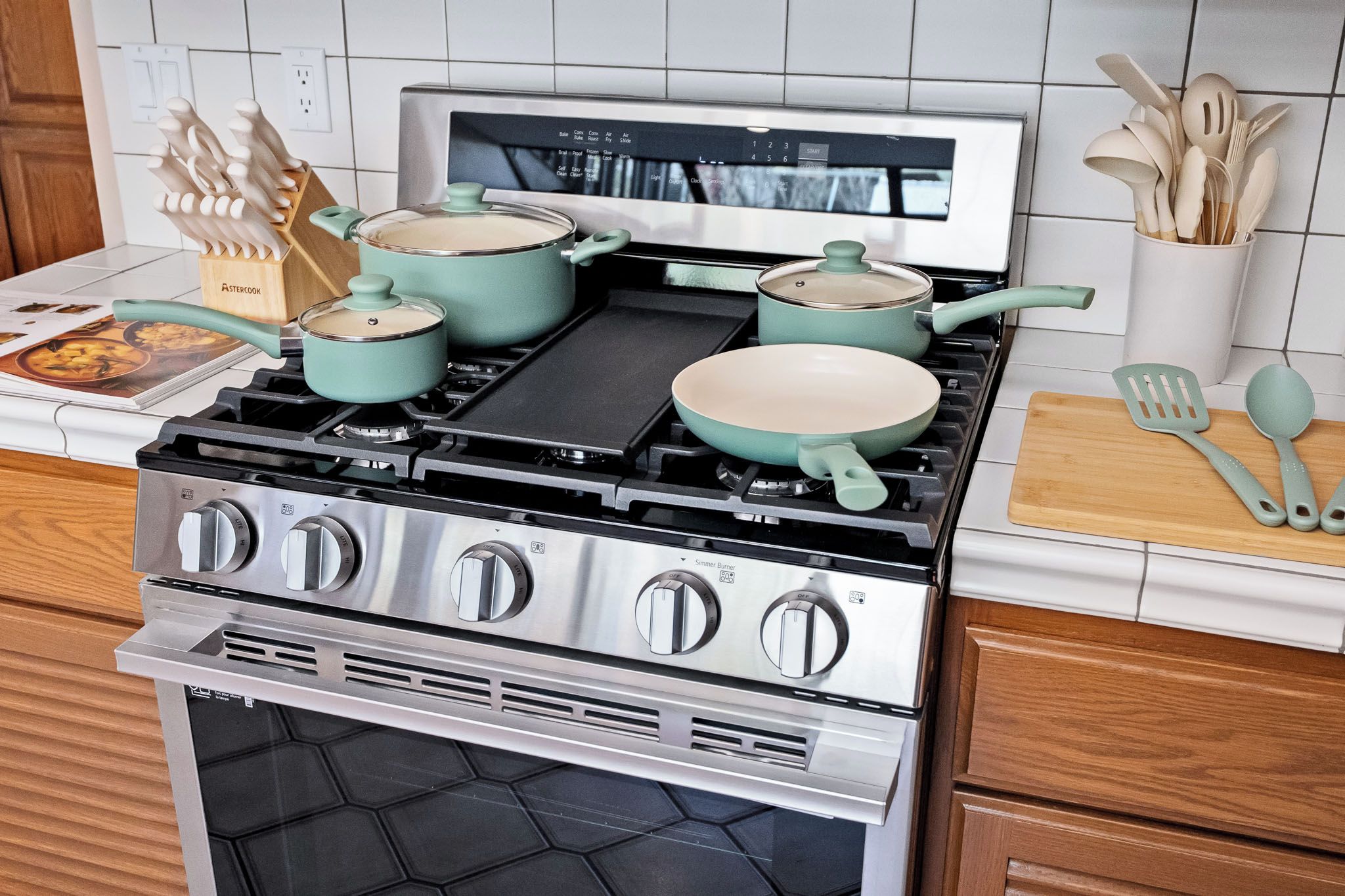 A stainless steel stove with four burners and a range hood.