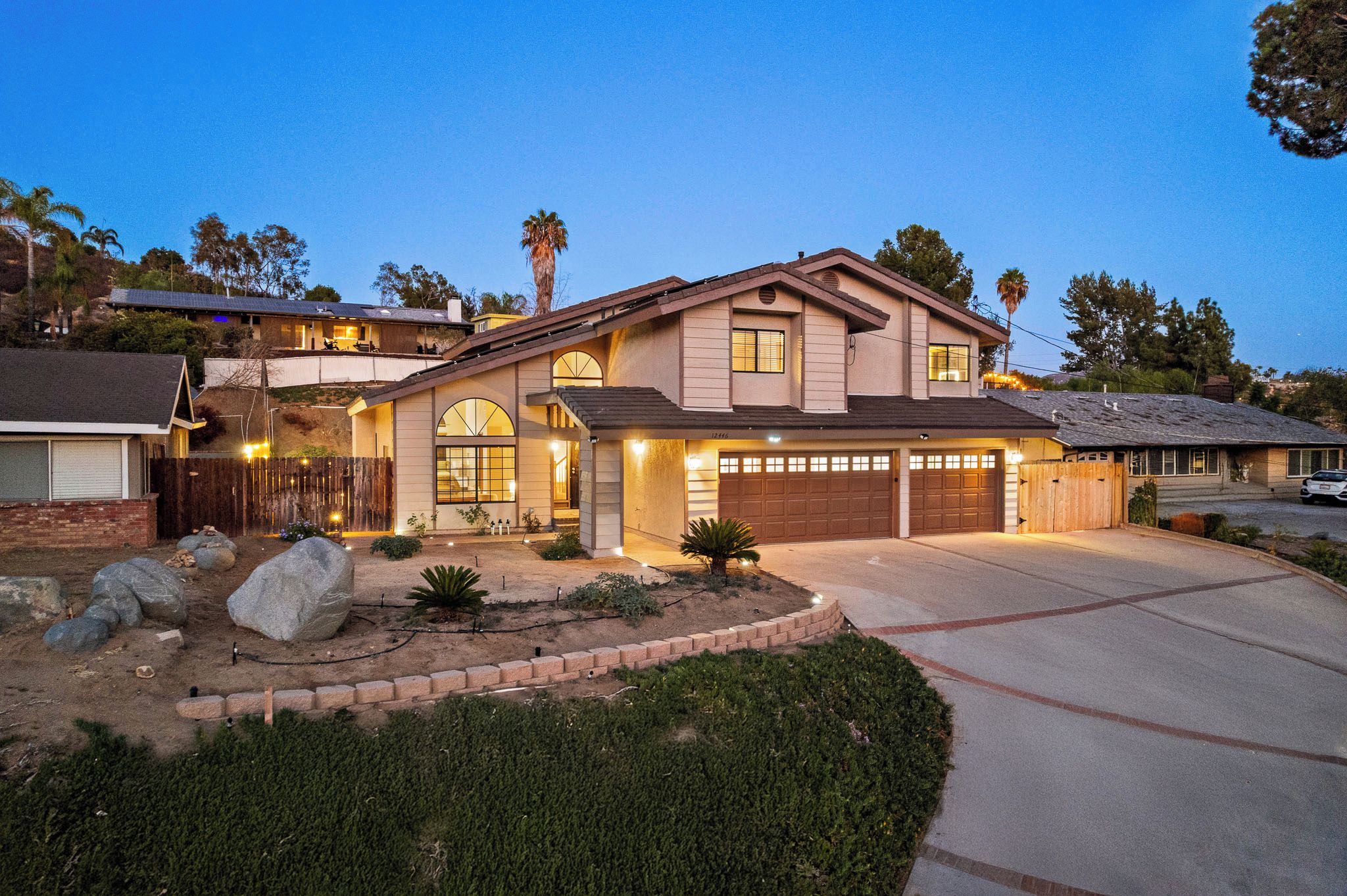 A two-story house with a garage, a driveway, and a landscaped front yard.