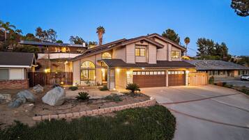 A two-story house with a garage, a driveway, and a landscaped front yard.