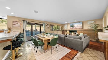 Una sala de estar moderna con comedor, chimenea y vistas al exterior.