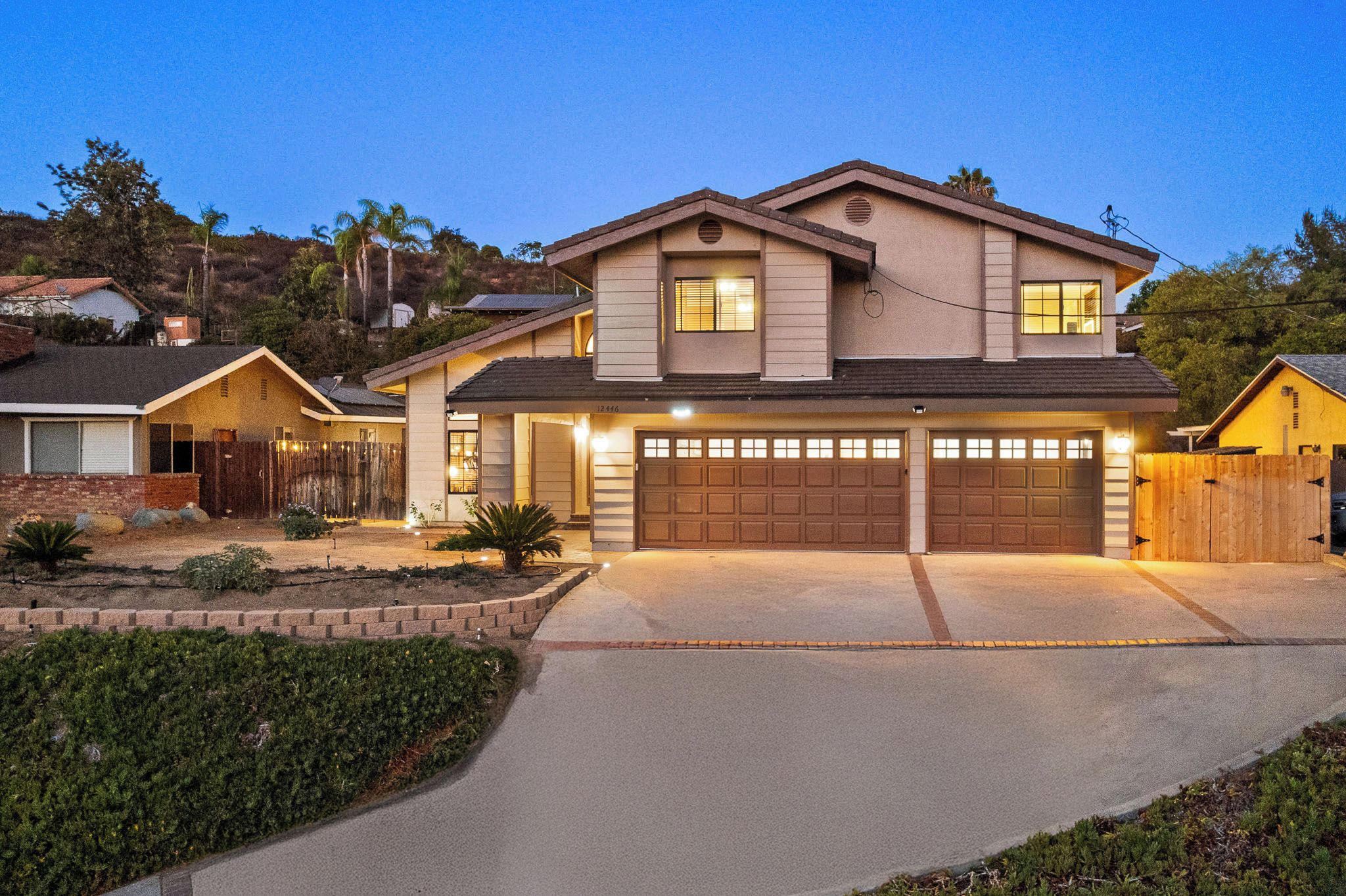 A two-story house with a garage, driveway, and landscaped garden.