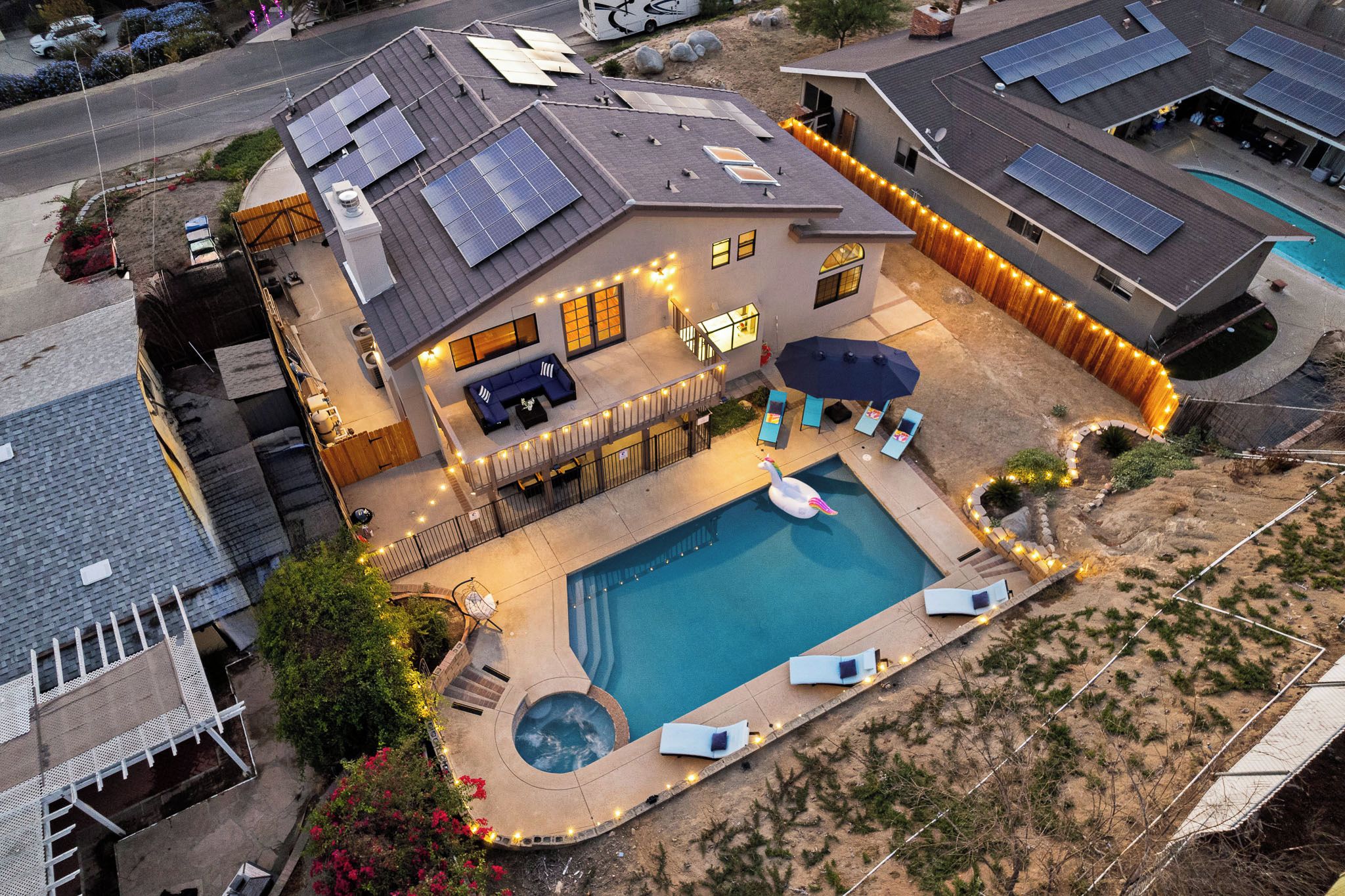 Imóvel residencial com piscina, painéis solares e área de varanda coberta.