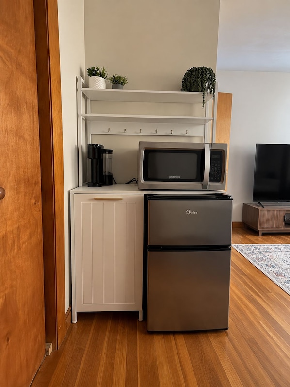 A compact kitchenette with a microwave, refrigerator, and a coffee maker on a white countertop. - Charming 2-bedroom house in Salem perfect for your getaway (Salem)