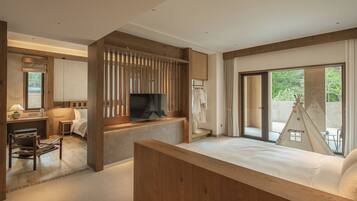 Una habitación de hotel moderna con una cama grande, televisión, escritorio y baño.