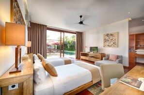 A hotel room with a bed, a desk, a TV, and a view of an outdoor pool area. - Casa Brio (Badung)