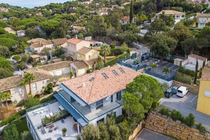 A residential area with a modern house featuring a flat roof, a balcony, and a patio with outdoor furniture. - Apt 2 Bedroom - Terrace Near Saint-tropez (Sainte-Maxime)