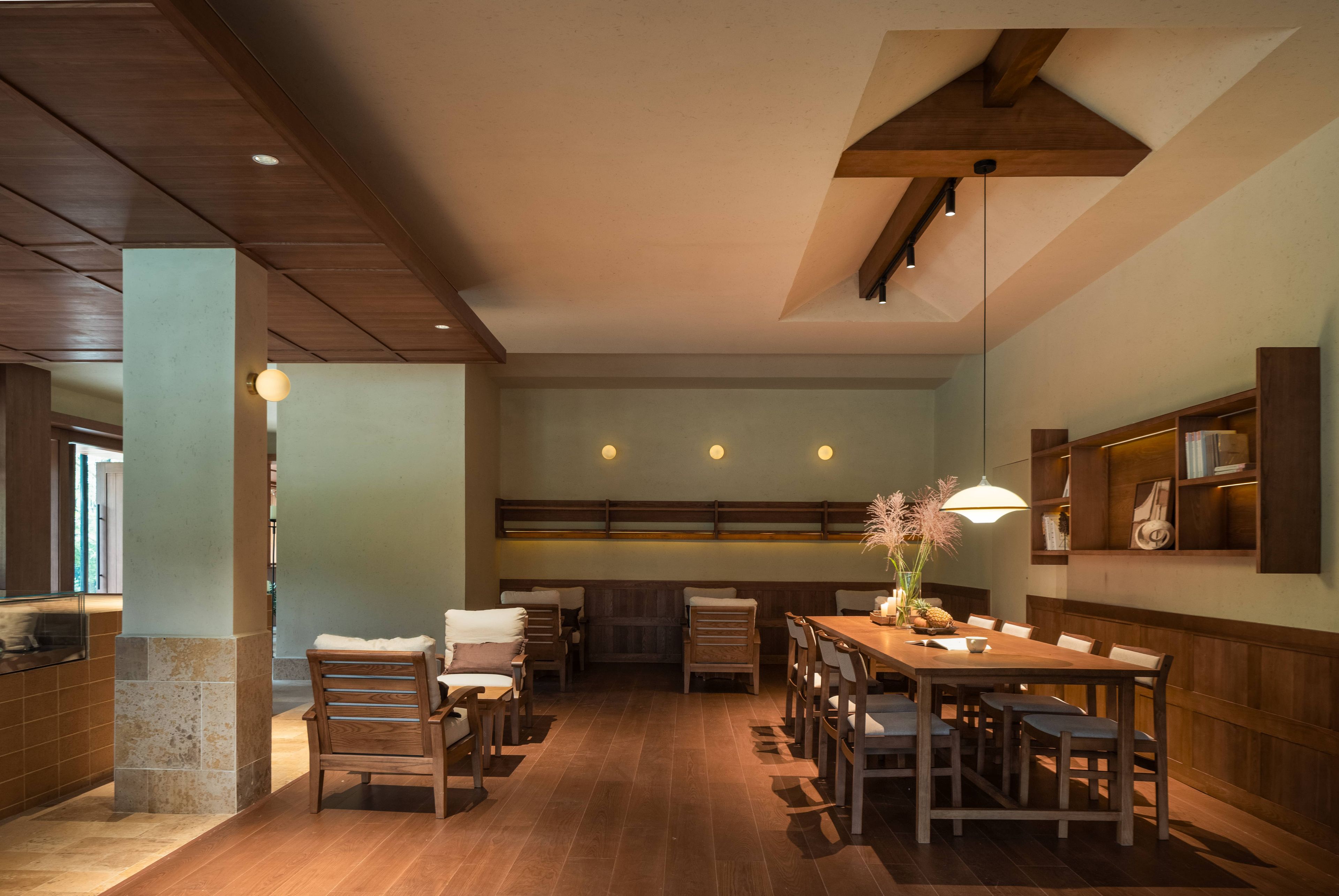 A dining area with wooden furniture, a central table, and a hanging light fixture.