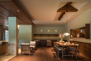 A dining area with wooden furniture, a central table, and a hanging light fixture.