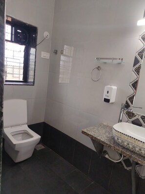 A bathroom with a toilet, a shower, and a sink. - Bliss paradise resort (Malvan)