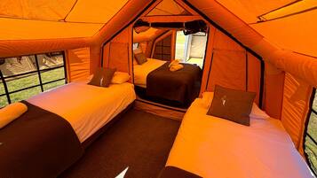 Una carpa con dos camas, una ventana y una puerta.