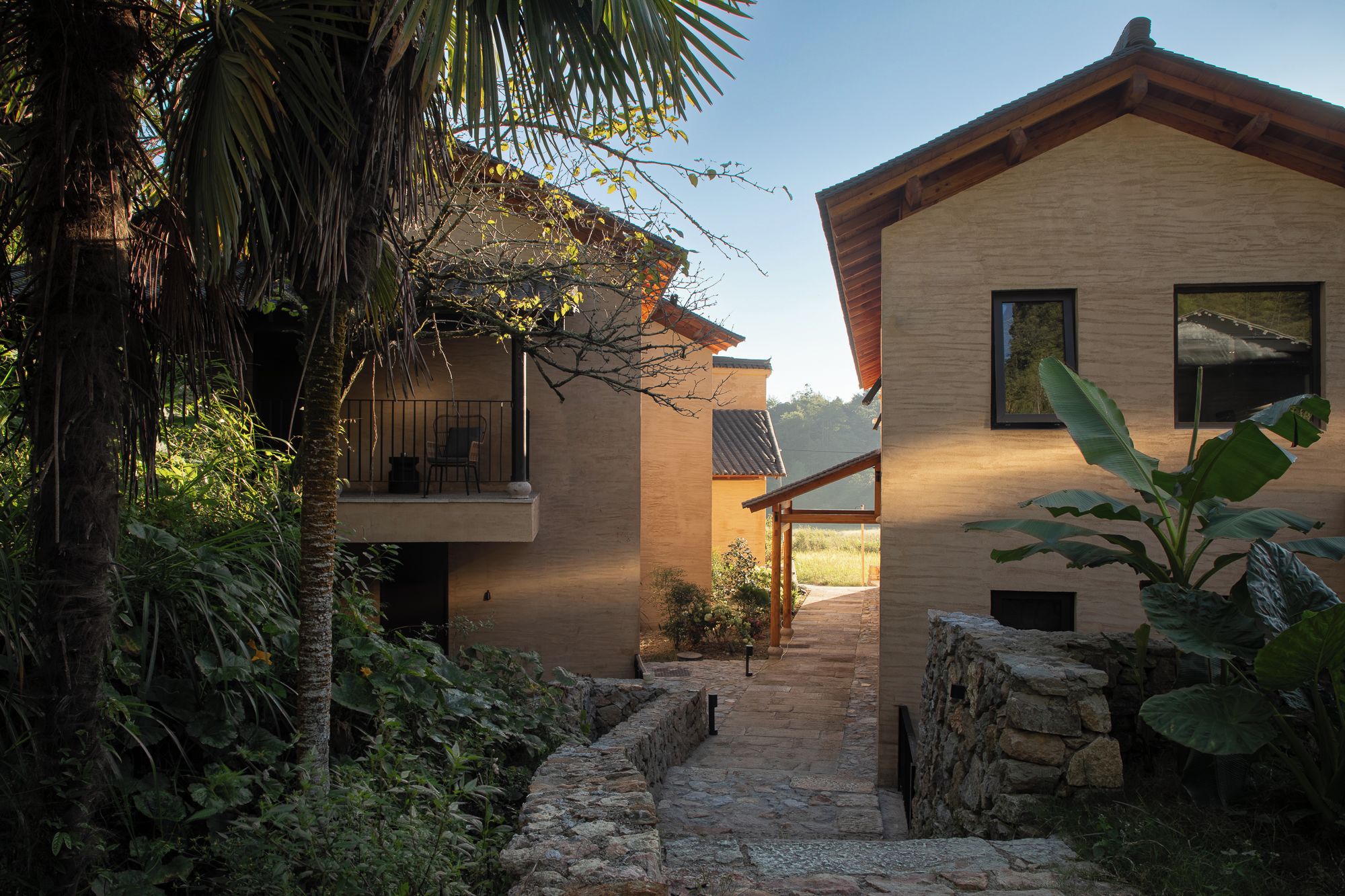 A modern building with a stone pathway leading to a wooden door.