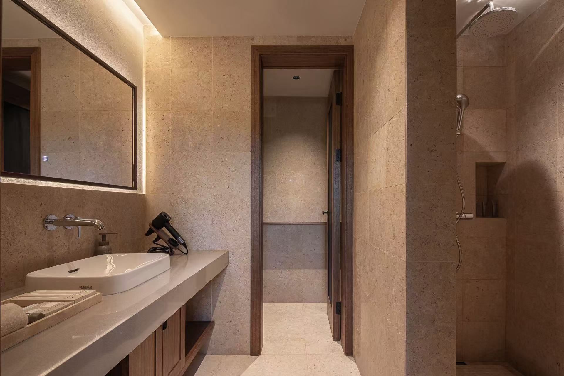 Un baño moderno con un espejo grande, un lavabo y una zona de ducha.