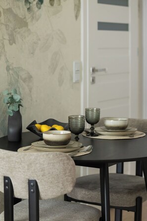 A dining table with a vase, a bowl of lemons, and two textured glasses. - Warsaw | Krochmalna 61 | Modern Studio | Air-conditioning (Warszawa)