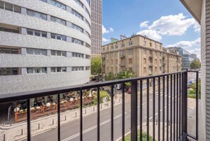 A balcony with a view of a street, buildings, and a clear sky. - Warsaw | Krochmalna 61 | Modern Studio | Air-conditioning (Warszawa)