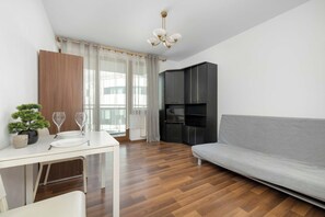 Un espace de vie moderne comprenant un coin repas, un canapé et une kitchenette.