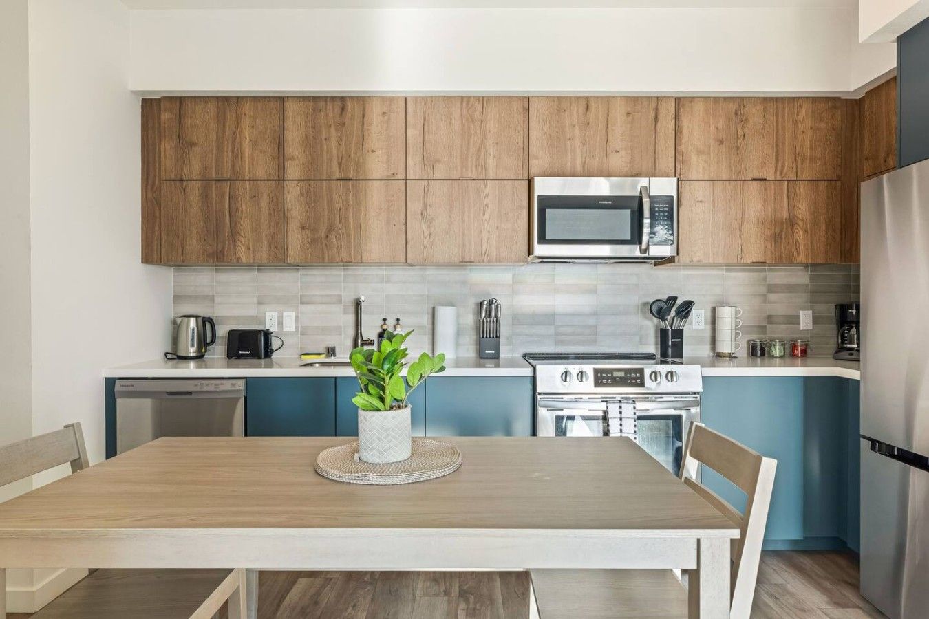 A modern kitchen with wooden cabinets, a stainless steel microwave, a gas stove, and a dishwasher.