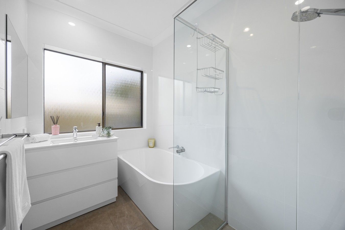 A modern bathroom with a freestanding bathtub, a glass-enclosed shower, and a large window providing natural light.