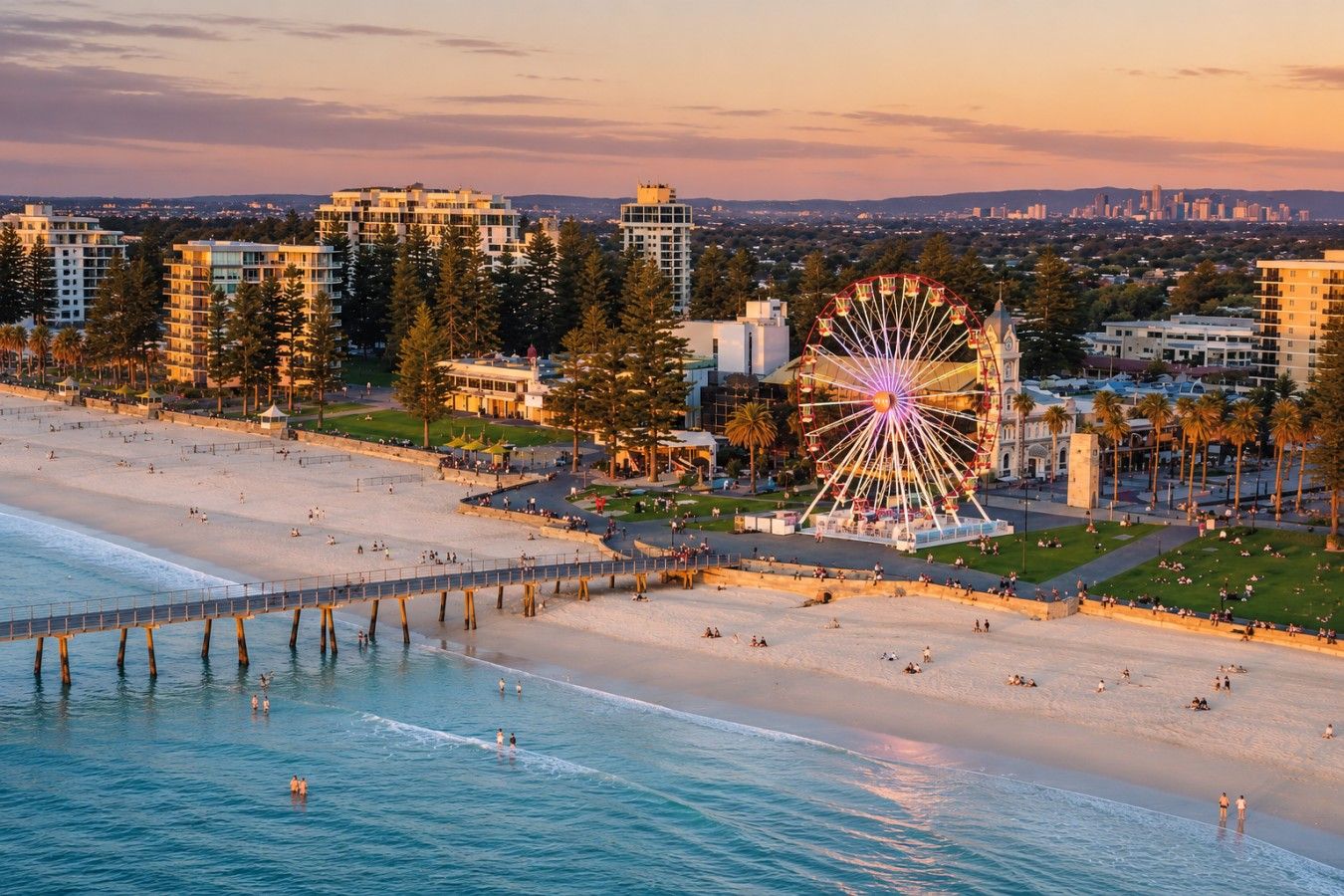 Une plage avec une grande roue, une jetée et, au loin, des immeubles de grande hauteur.