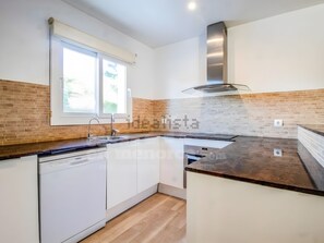 A kitchen with a window, a dishwasher, and a brick backsplash. - Villa 'Santal' with Private Terrace, Wi-Fi and Air Conditioning (Son Parc)