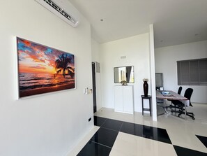A modern office space with a large painting of a sunset, a conference table, and a white cabinet. - A7 - Luxurious 64 sqm Serviced Apartment Near Karon Beach (Tambon Karon)