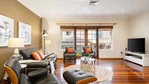 A modern living room with a leather sofa, a coffee table, and a television.