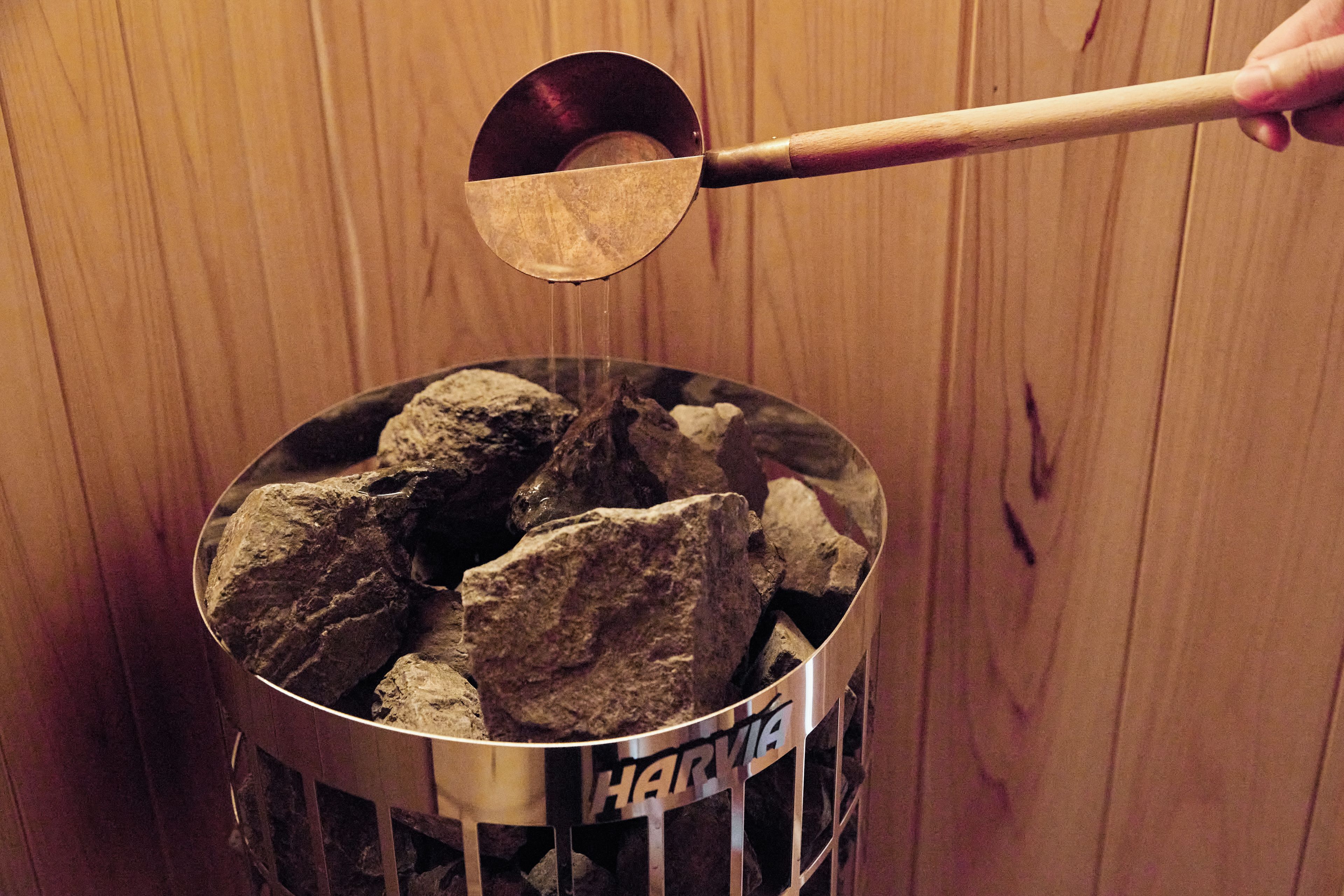Un recipiente metálico con piedras y una cuchara de madera.