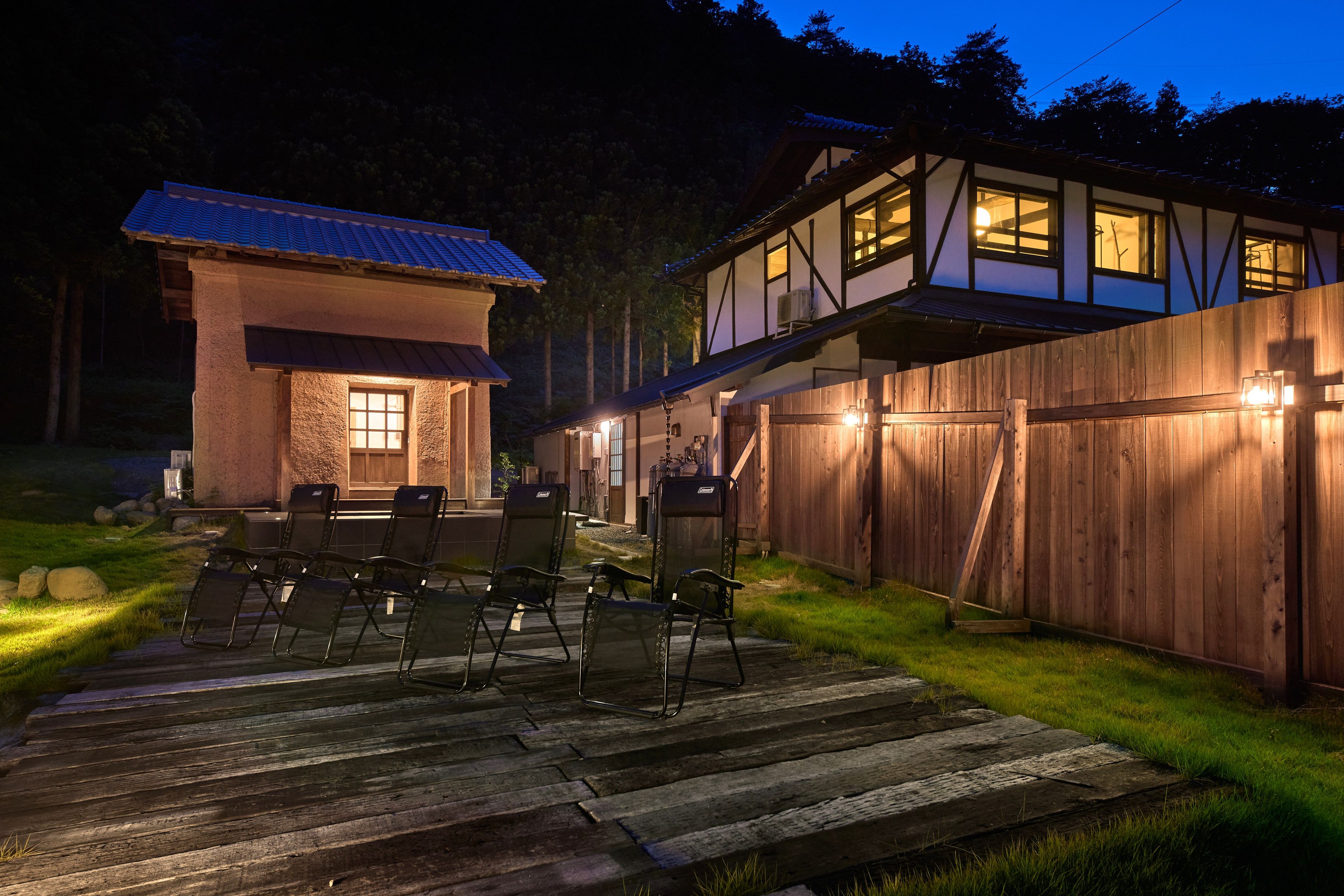 A two-story building with a wooden deck and outdoor seating area.