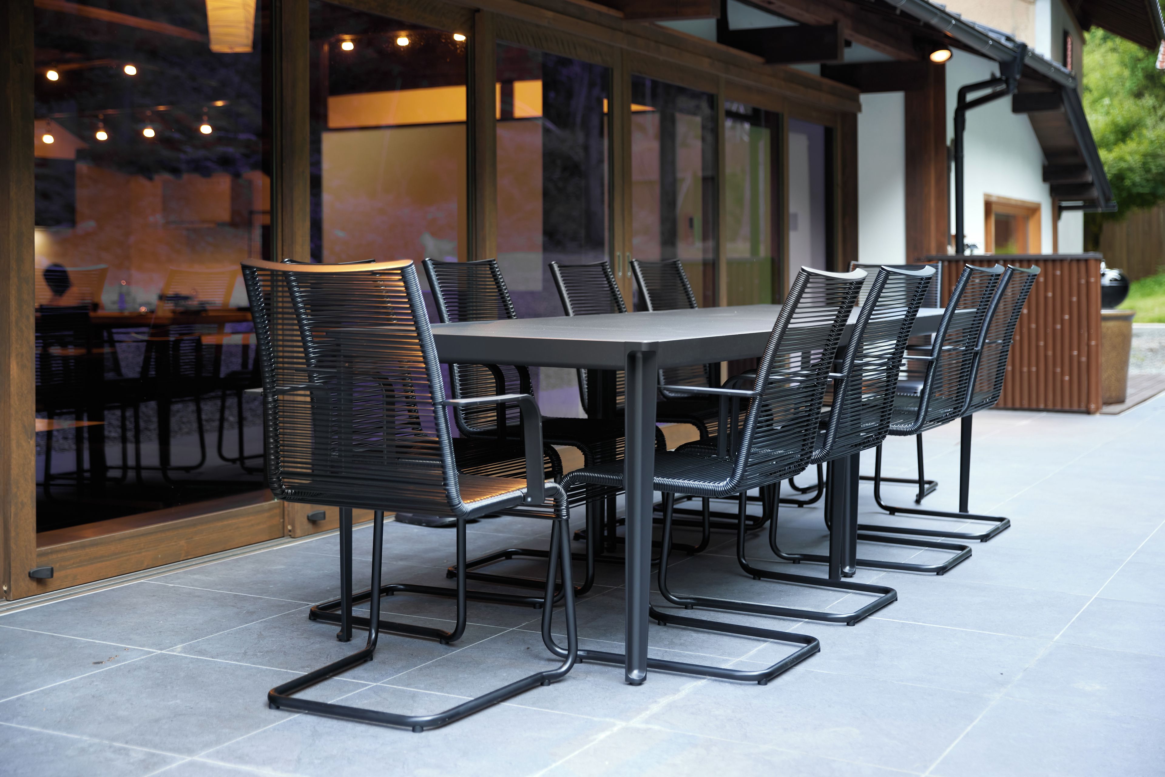 An outdoor dining area with a rectangular table and six chairs.