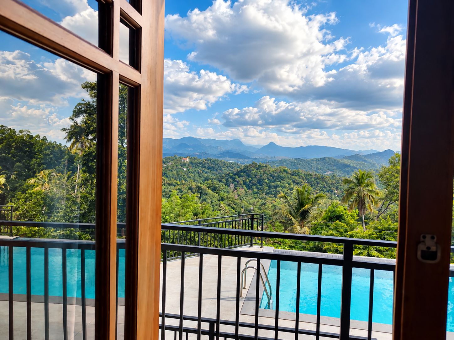 Piscina con vistas a un paisaje montañoso y abundante vegetación.