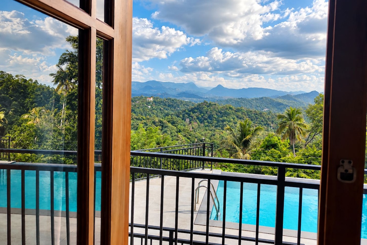 Piscina con vistas a un paisaje montañoso y abundante vegetación.