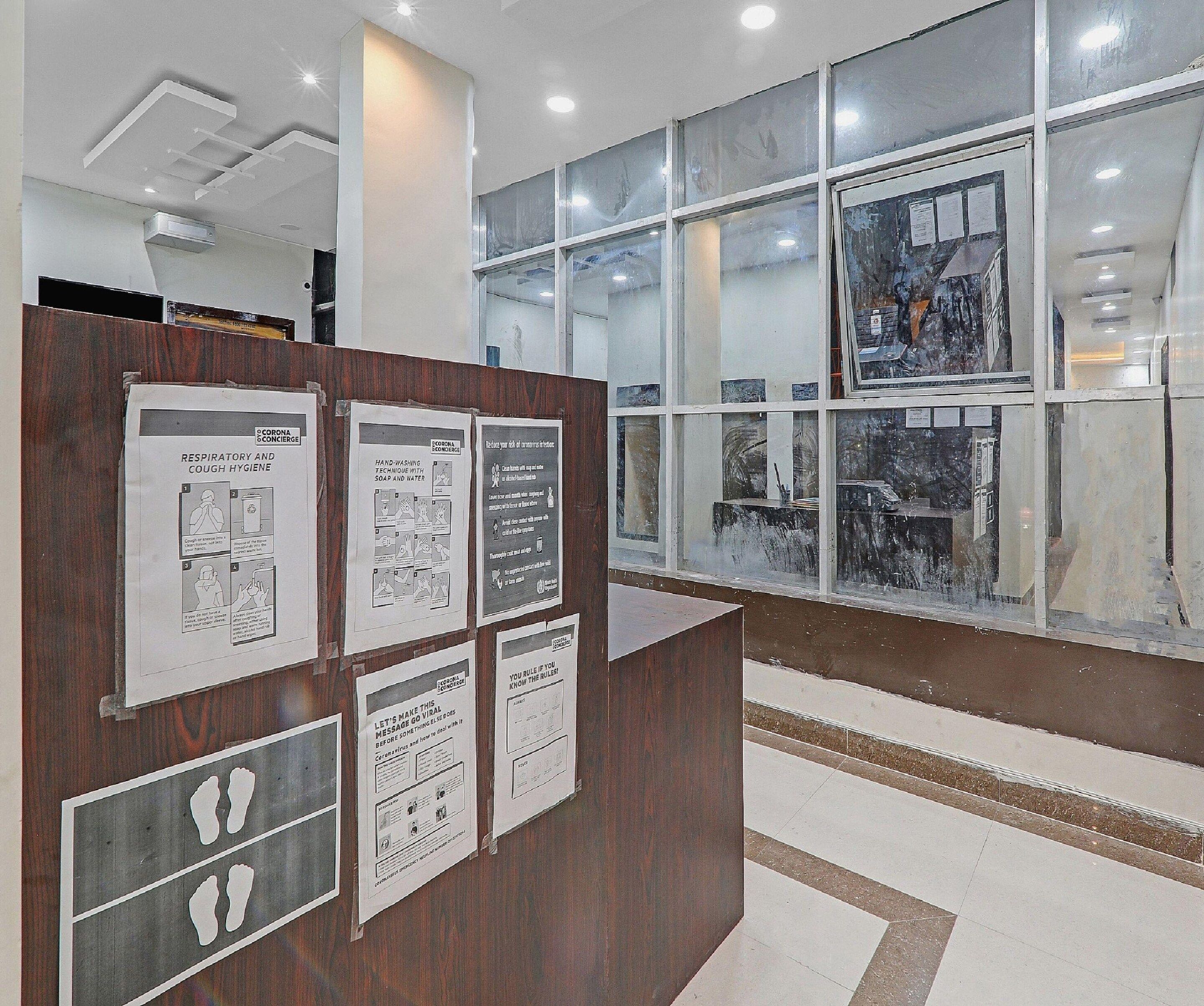 A reception area with informational posters on hygiene and health guidelines.