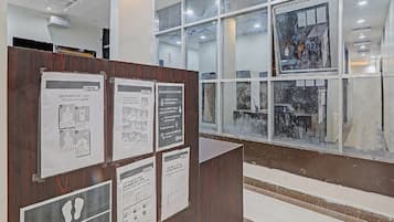 A reception area with informational posters on hygiene and health guidelines.
