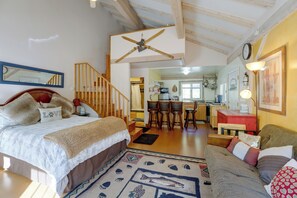 Een gezellige slaapkamer met een bed, een houten trap en uitzicht op de keuken.
