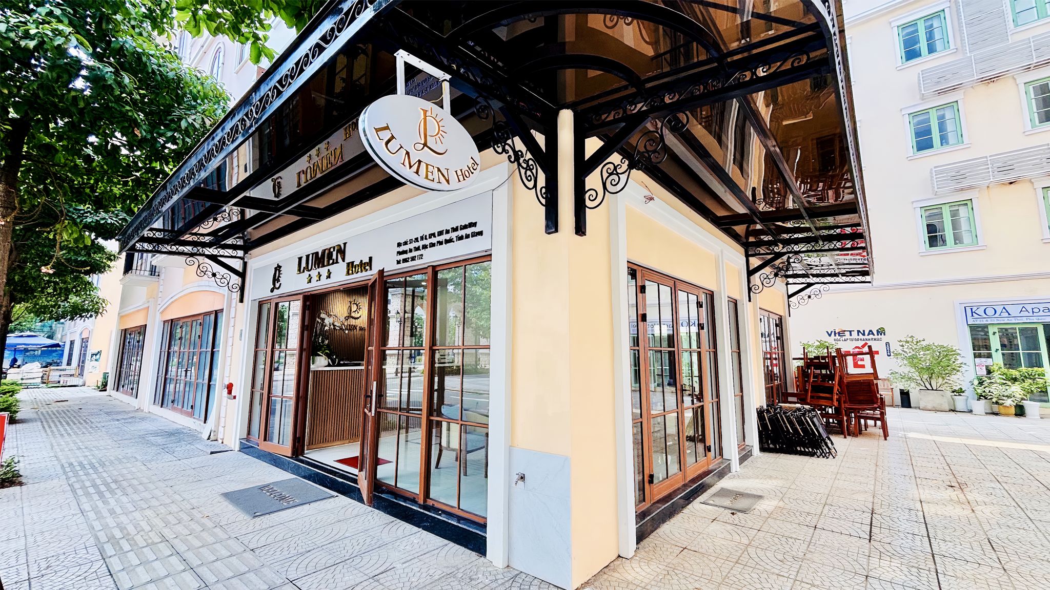 A hotel with a traditional facade, large glass windows, and a covered entrance area.
