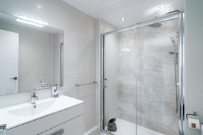 A modern bathroom with a glass-enclosed shower, a white sink, and a mirror. - Apartment in Nerja With Beachfront Views (Nerja)