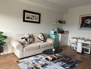 Bright living space with cozy seating, dining nook, and handy kitchenette
