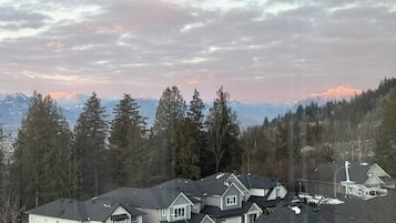 Scenic mountain-view neighborhood framed by trees and glowing sunset skies