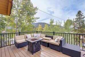 A covered outdoor seating area with a sectional sofa and a fire table. - Mtn-View Cabin Escape in Heart of Grand Lake (Grand Lake)