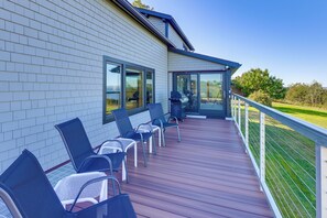 Una veranda coperta all'aperto con sedie e zona barbecue.