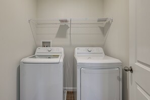 A laundry room with two stacked front-loading washing machines and a drying rack above. - Dunkirk Group Getaway w/ Easy D.C. Access! (Dunkirk)