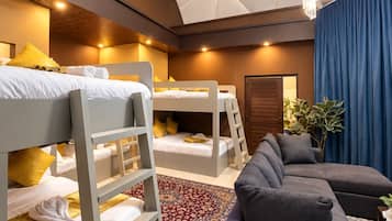 A modern bedroom with bunk beds, a grey sofa, and a chandelier.