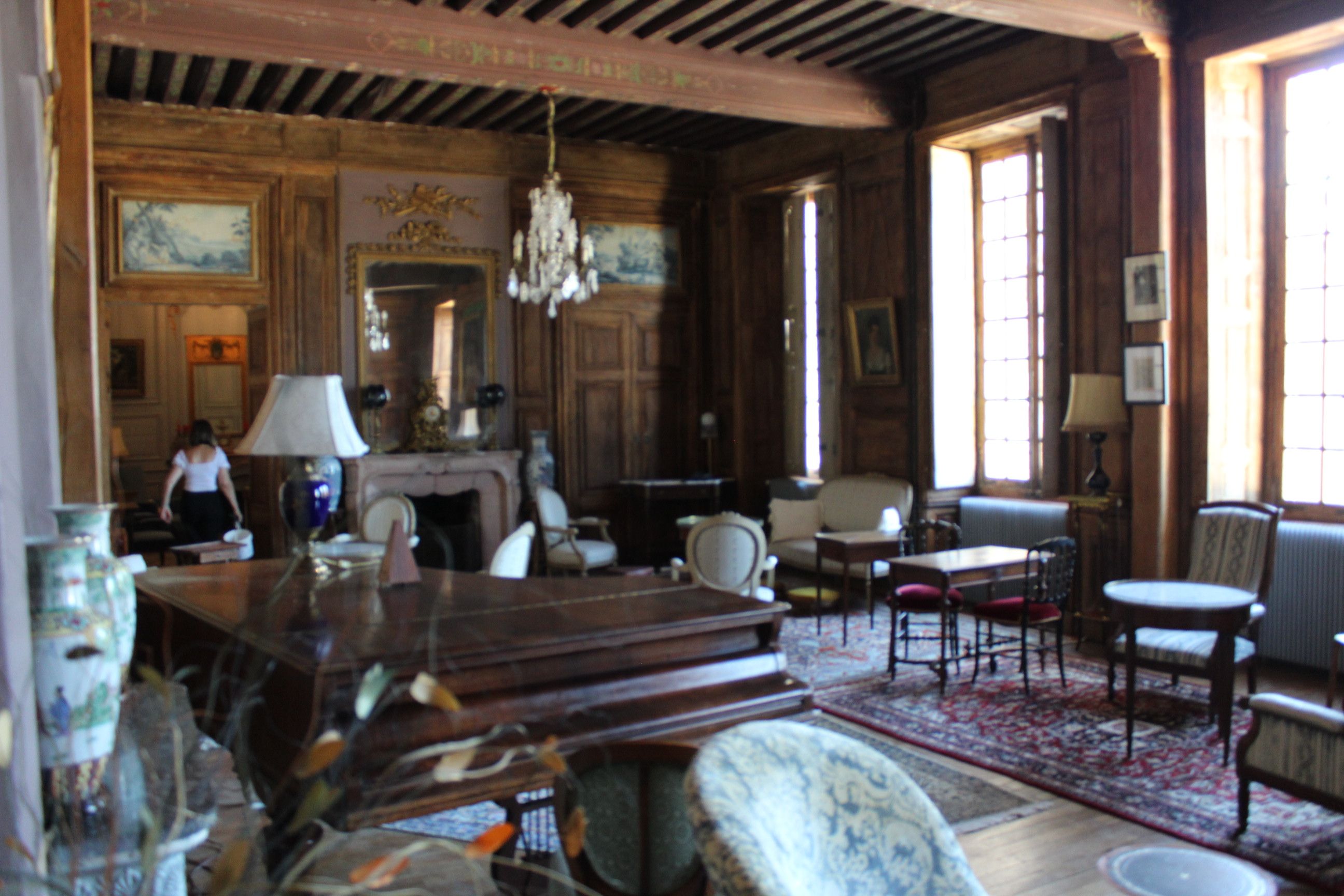 Une pièce avec une cheminée, des meubles en bois et un lustre.