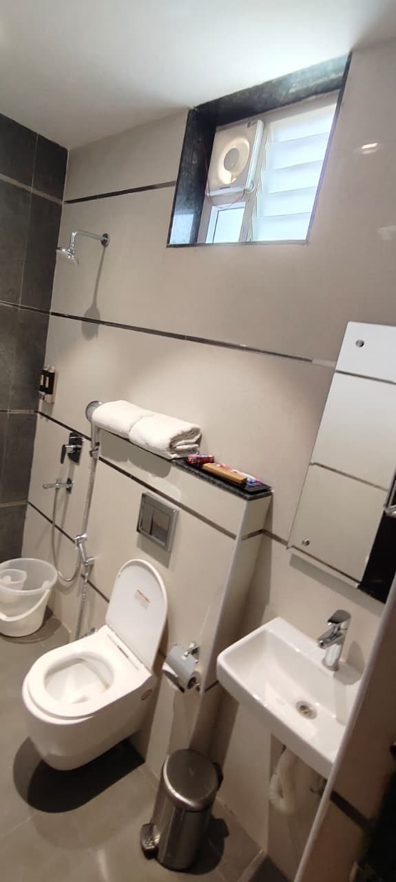 A modern bathroom with a toilet, sink, and shower.