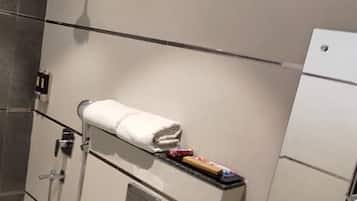 A modern bathroom with a toilet, sink, and shower.