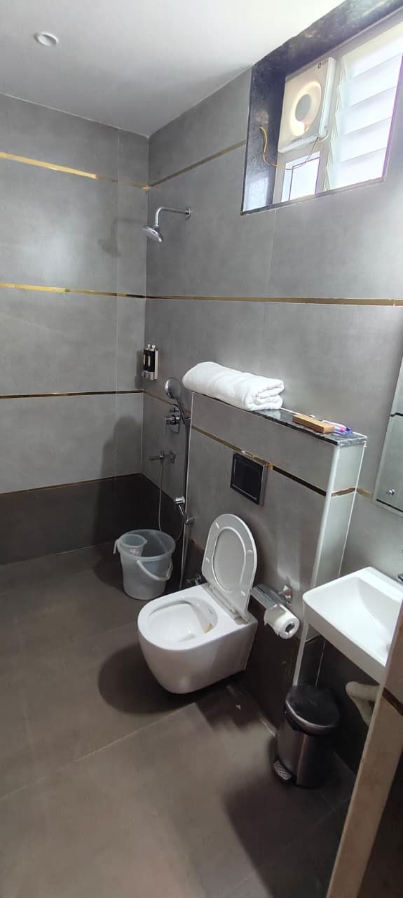 A modern bathroom with a shower, toilet, and sink.