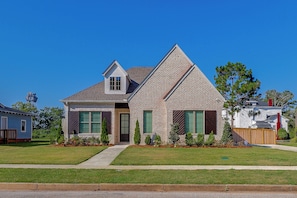 A two-story house with a gabled roof, a front porch, and a well-maintained lawn.