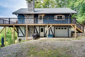 Ein zweistöckiges Haus mit einem Steinkamin, einer Veranda und einer Garage.