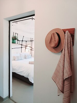 A bedroom with a bed, a hanging plant, and a hat on the wall. - A beautiful home in central Livingstone with a Pool near Victoria Falls (Livingstone)