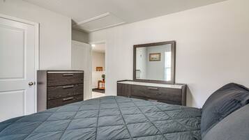 A bedroom with a bed, dresser, and mirror.