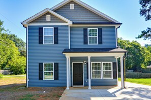 A two-story house with a front porch, a garage, and a covered entryway.